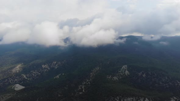 Shot From a Drone. Beautiful Mountains Covered with Pine Forest By the Sea. Clouds Over the alt