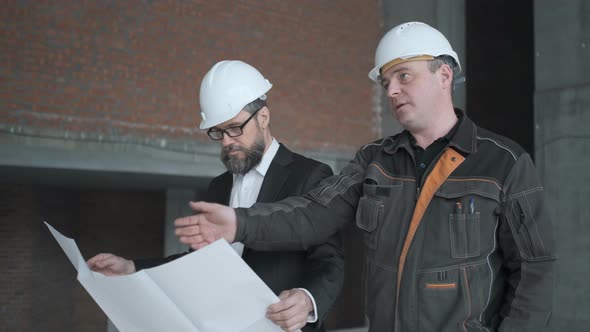 Two Engineers Meet At Construction And Consult Building Project. Two Engineers alt