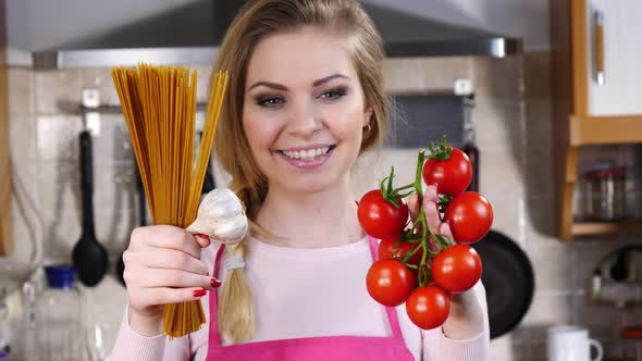 Woman Holds Pasta and Tomatoes