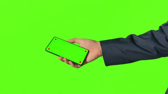 Business man hand shows mobile smartphone with green screen