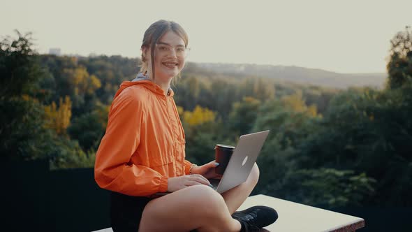 The Young Woman with Red Hair Caught in a Bun Looks in Front of the Room and Smiles Wide Sitting in alt