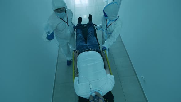 Doctors Transport Sick Patient on Stretcher During Pandemic. Coronavirus Pandemic Concept. alt