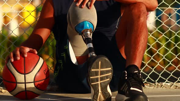 Man with Leg Prosthesis Playing Basketball in Tropical Sea Side at Sunset Time alt