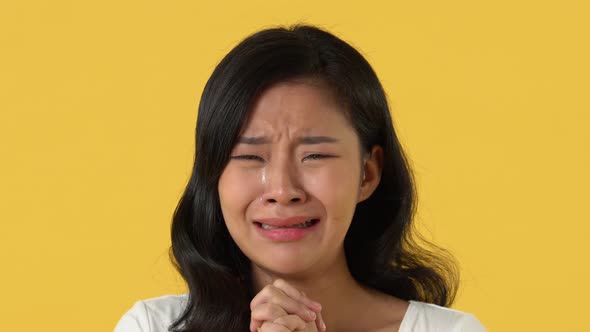 Disappointed Asian woman crying with tears on her face