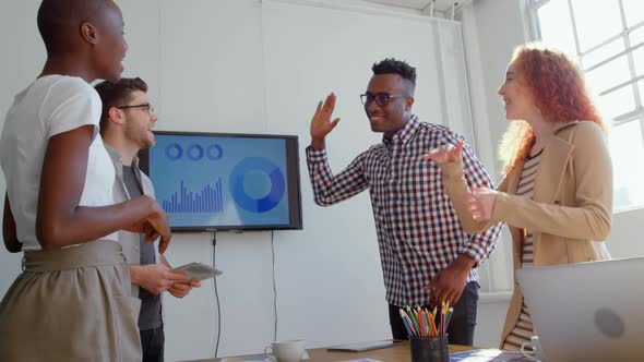 Low angle view of young mix-race business team giving high-five in meeting room of modern office 4k alt