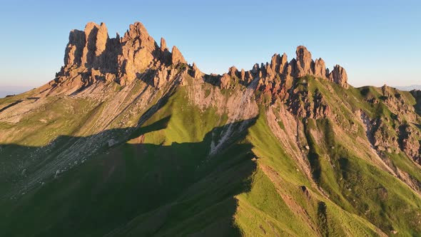 Dolomites mountains peaks with a hiking path on a summer sunrise alt