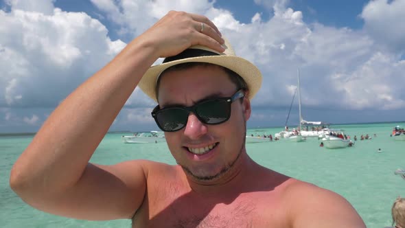 Portrait Young Man in Summer Hat Taking Selfie Video on Catamaran Yacht with Caribbean Sea Water alt