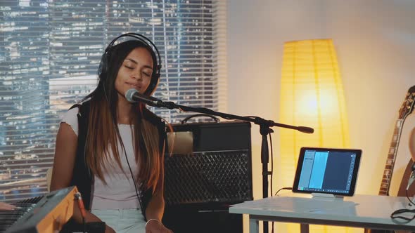 Attractive Mixedrace Girl Emotionally Singing Into Microphone in Home Studio alt