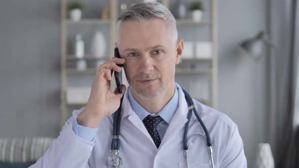 Senior Doctor Discussing with Patient During Phone Talk alt