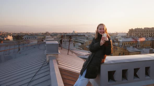 Happy Teen Girl Is Taking Pictures On Her Smartphone On The Roof In Europe City