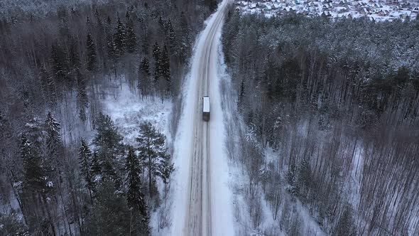 A Truck is Driving on the Road in the Winter Siberian Taiga