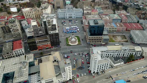 Aerial orbit of buildings and cars driving in the streets surrounding Plaza Sotomayor, civic center alt
