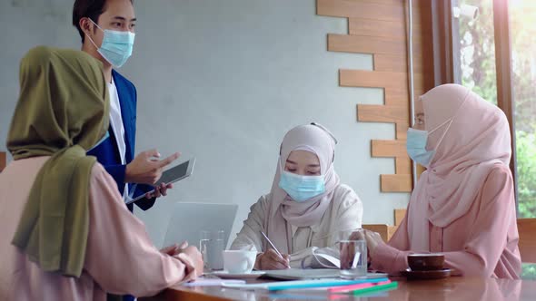 Upwardly mobile Asian Muslim business entrepreneur SME start up group of young man and women, discus alt