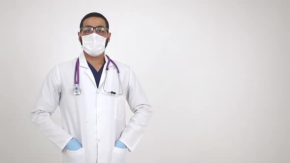 Arab young doctor in medical mask smiling at camera. The end of the coronavirus pandemic alt