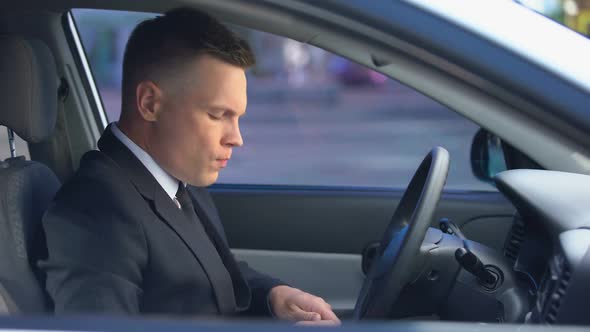 Nervous Man in Business Suit Taking Drugs in Car, Opening Window, Feeling Dizzy alt