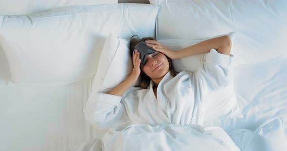 Woman Awakes Smiling and Stretches on Large Hotel Bed