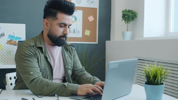 Middle Eastern Guy Using Laptop Then Hitting Table and Leaving Feeling Unhappy and Disappointed in alt