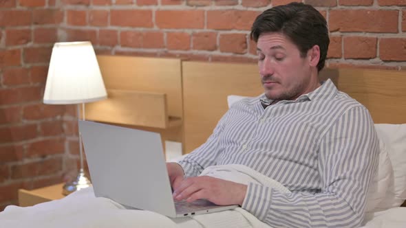 Middle Aged Man with Laptop Sleeping in Bed alt