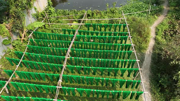 Aerial view of a person hanging to dry red cloths in Dhaka, Bangladesh. alt