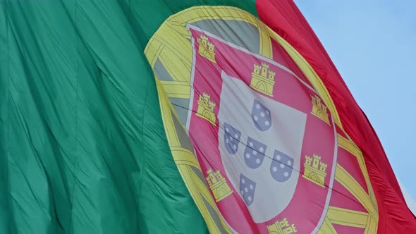 Closeup of National Flag of Portugal Waving in the Wind on Clear Sunny Day at Blue Sky alt