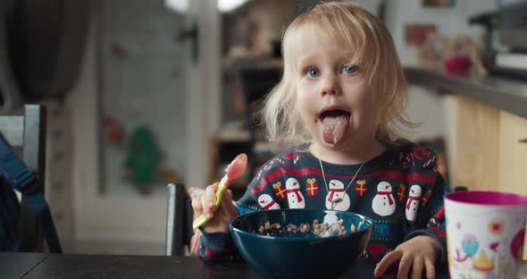 Cute Child Girl Eats Buckwheat Porridge As a Dinner on Evening in Dinning Room alt
