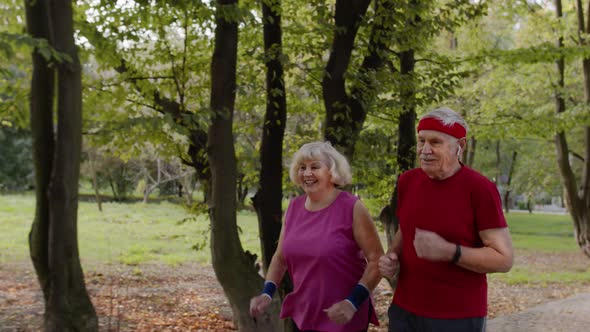 Sporty Mature Family Couple Jogging Together. Senior Husband and Wife Doing Cardio Workout Exercises alt