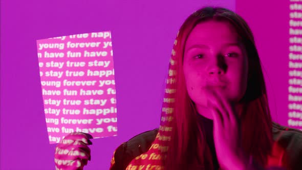 Portrait of Teen Girl Checking on Pink Wall with Tags of Youth alt