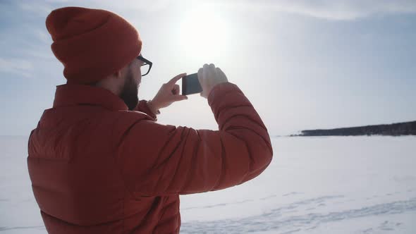 Man with Smartphone, Making a Picture of Winter Nature Without People