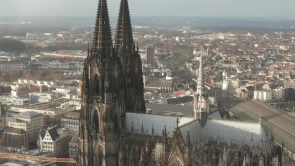 AERIAL: Circling Around Beautiful Cologne Cathedral with Central Train Station in Beautiful Hazy alt