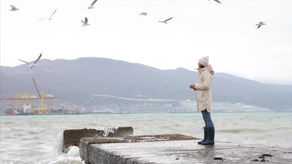 Young Woman is Feeding a Seagulls