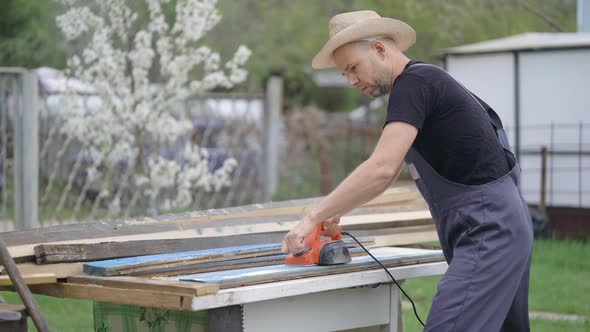 The Man Works As an Electric Bank. Processing Old Boards. Dealing with Wood alt