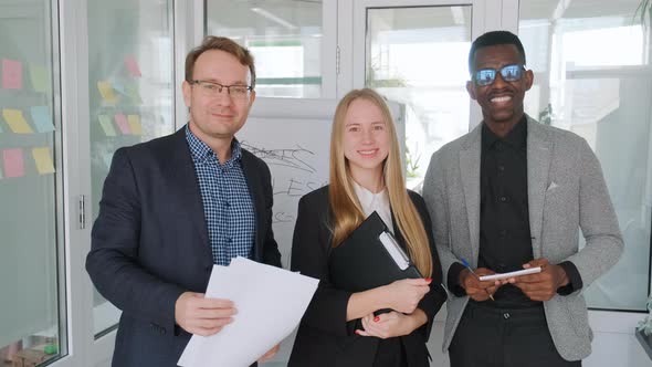 Diverse Creative Group Standing in Office and Looking in Camera with Smile