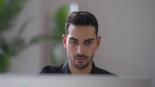 Closeup Portrait of Young Nervous Middle Eastern Man Slapping Computer Monitor in Home Office alt