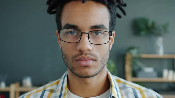 Slow Motion Portrait of Serious African American Man Hipster Looking at Camera at Home alt