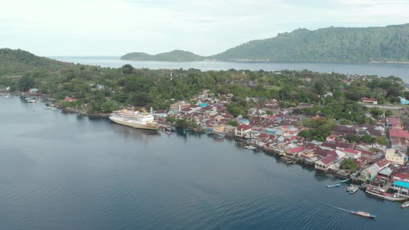 Aerial: flying over passenger ship Pelni in Bandaneira harbor Indonesia alt