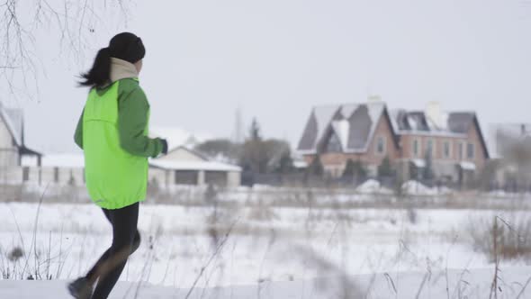 Woman Jogging Outdoors in Winter alt