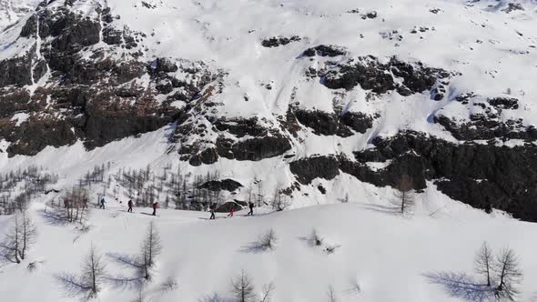 Group of ski touring on skin uphill in a line. Ski touring in big mountains alt