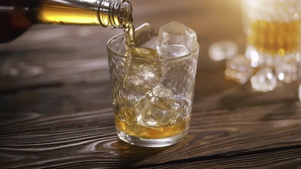 Barman Pouring Whiskey in a Glass with Ice 