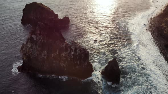 Aerial View of Ocean Waves Crashing Into the Seaside at Sunrise