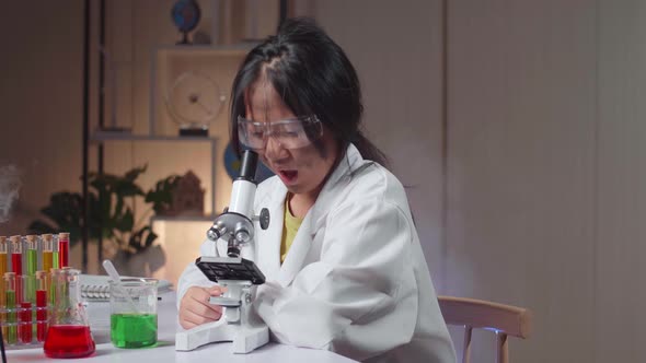 Excited Young Asian Scientist Girl With Dirty Face Looking At Microscope And Say Wow alt
