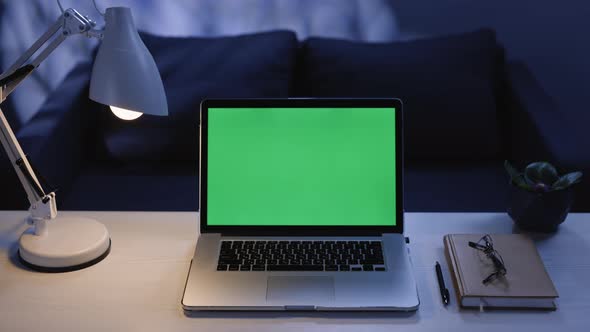 Close Up Shot of Modern Chroma Key Green Screen Mock Up Laptop Computer Set Up For Work on Desk