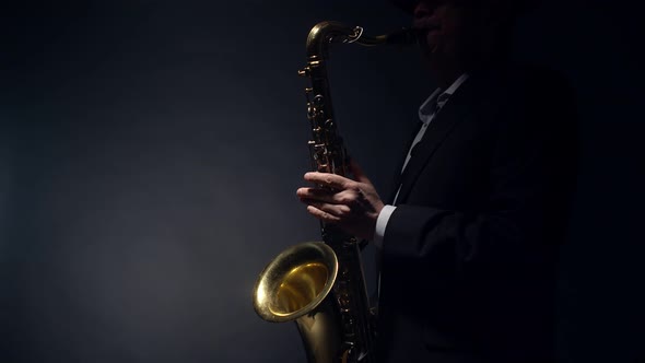 Saxophonist Plays a Shiny Gold Saxophone By Blowing Into the Mouthpiece and Pressing the Flaps with alt