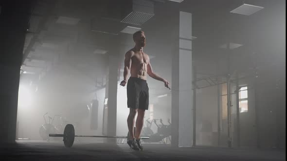Young Man Exercising Using Skipping Rope in Gym alt