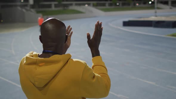 African american male coach clapping watching disabled male athlete with running blade training alt