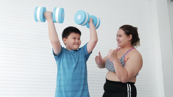 Fat mother encouraging Fat son while lifting dumbbells exercise for diet
