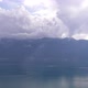 Aerial hyper lapse of clouds rolling over mountains near lake - VideoHive Item for Sale