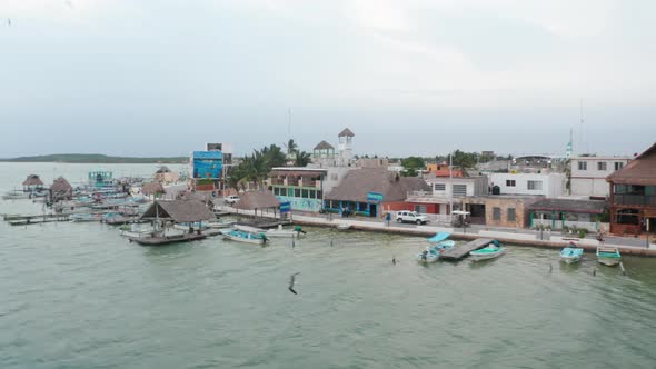 Aerial View of Lagoon Coastal Town with Many Small Boats and Low Buildings alt