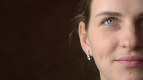 Half Face of a Beautiful Young Woman Looking and Smiling at the Camera alt