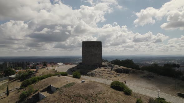 Visitors walking towards Castle of Guarda, hilltop keep landmark.