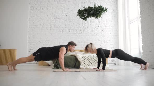 Man and Woman Doing Push Up Exercises and Giving Each Other High Five at Home